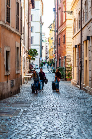 Rome, Italy - November 18, 2018: People walking with their luggage by the ancient medieval Old Town paving stone street in Rome, Italyのeditorial素材