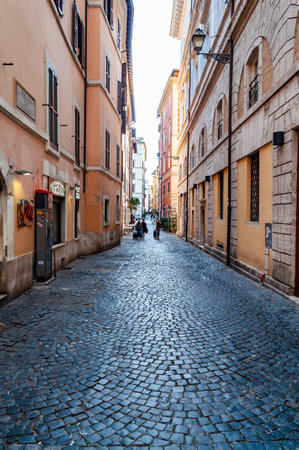 Rome, Italy - November 18, 2018: People walking with their luggage by the ancient medieval Old Town paving stone street in Rome, Italyのeditorial素材