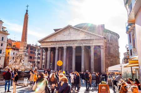 Rome, Italy - November 18, 2018: People walking on the square of the famous Pantheon temple of all the gods is a former Roman temple with bright sun rays illuminating from above behind the templeのeditorial素材