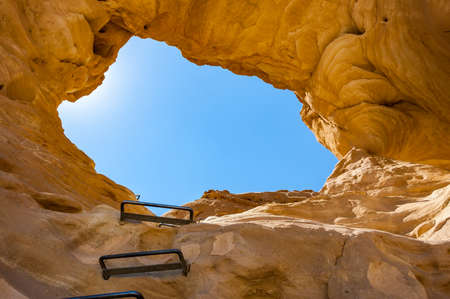 The Arches, amazing round hole in the rock, closed arch in ancient cooper mines canyons and mountains range in Timna National Park in Israelの写真素材