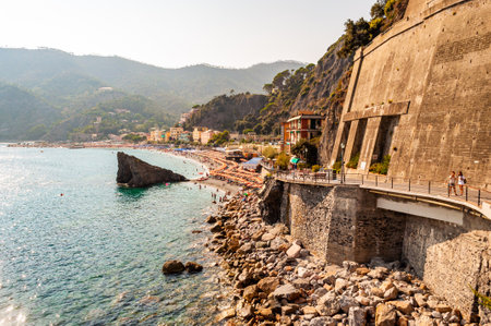 Monterosso Al Mare, Italy - September 02, 2019: On the way to the famous beach in Monterosso Al Mare, Cinque Terre. High walkways, rocks in the sea, vibrant cityscape surrounded by green mountainsのeditorial素材