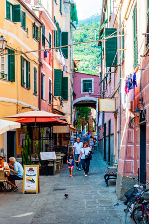 Monterosso Al Mare, Italy - September 02, 2019: People are walking, traveling by a cozy vibrant streets full of small businesses on the ground floor in Monterosso Al Mare, Cinque Terre, Italyのeditorial素材