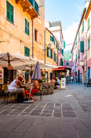 Monterosso Al Mare, Italy - September 02, 2019: People are walking, traveling by a cozy vibrant streets full of small businesses on the ground floor in Monterosso Al Mare, Cinque Terre, Italyのeditorial素材