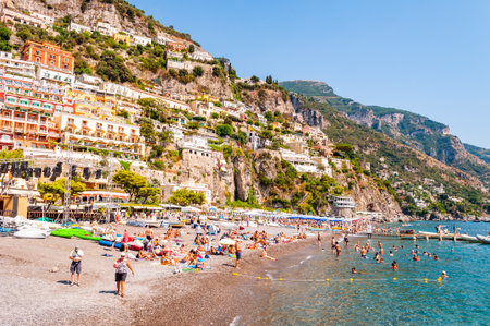 Positano, Italy - September 05, 2019: Amazing medieval Positano cityscape on rocky landscape, people on the beach, tourists walking by the cozy streets and promenades full of apartments and businessesのeditorial素材