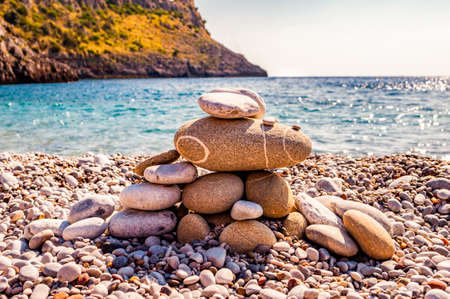 Abstract animal sculpture made of flat stones on the beach. Stone balancing is the art discipline, or hobby in which rocks naturally balanced on top of one another in various positions. Italyの写真素材