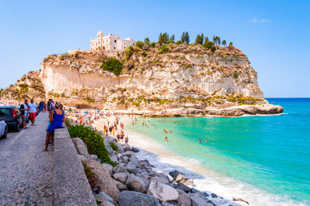 Rotonda Beach, Tropea, Calabria, Italy - September 07, 2019: Landscape view on famous Rotonda Beach full of resting sunbathing and swimming people. Sanctuary Santa Maria on the peak of a massive cliffのeditorial素材