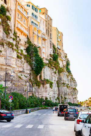 Tropea, Calabria, Italy - September 07, 2019: Famous sea promenade in Tropea with high cliffs with built on top city buildings and apartments. Parking area on a side of a street. Overgrown rocks baseのeditorial素材