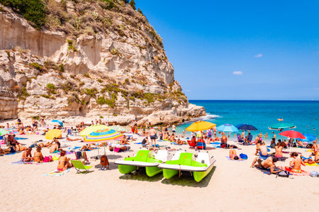 Rotonda Beach, Tropea, Calabria, Italy - September 07, 2019: Landscape view on famous Rotonda Beach under the cliff full of sunbathing and swimming people. Popular landmark in Tropea city, Italyのeditorial素材