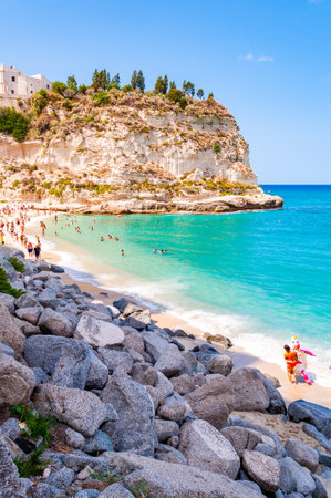 Rotonda Beach, Tropea, Calabria, Italy - September 07, 2019: Landscape view on famous Rotonda Beach full of resting sunbathing and swimming people. Sanctuary Santa Maria on the peak of a massive cliffのeditorial素材