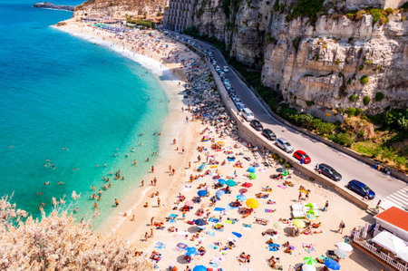 Tropea, Calabria, Italy - September 07, 2019: Rotonda beach full of people. Amazing Italian beaches. Sea promenade scenery in Tropea with high cliffs with built on top city buildings and apartments.のeditorial素材