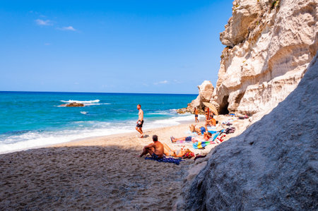 Tropea, Calabria, Italy - September 07, 2019: People resting on tiny closed by massive white rocks beach with blue Tyrrhenian sea on the backgroundのeditorial素材