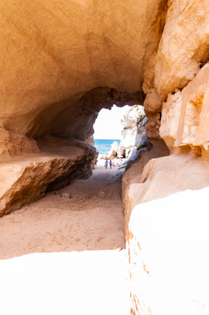 Tropea, Calabria, Italy - September 07, 2019: Amazing seascape view from unique sea cave on famous Rotonda beach. Tourists walking through the grotto, resting on small beach. Tyrrhenian sea landscape.のeditorial素材