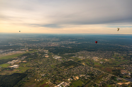 Vilnius, Lithuania - September 14, 2021: White and red hot air balloons fly above Vilnius capital of Lithuania. Vilnius cityscape view from the skyのeditorial素材