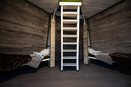 Two single beds with linen mounted in niches of a room. Pyramid shape bungalow summer house. Angled...