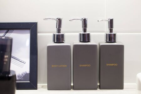 Metal liquid soap bottleon wooden shelf and Towels Bathroom accessories.の写真素材
