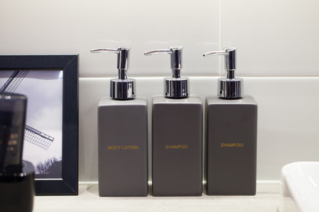 Metal liquid soap bottleon wooden shelf and Towels Bathroom accessories.の写真素材