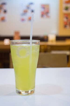 Iced Green tea with a straw on tableの写真素材