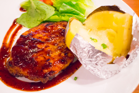 Grilled chicken steak on plate with baked potato and vegetable,Traditional cuisine. Grill kitchen.の写真素材