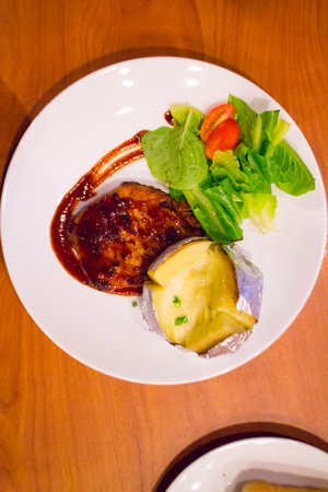 Grilled chicken steak on plate with baked potato and vegetable,Traditional cuisine. Grill kitchen.の写真素材