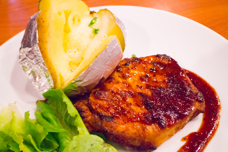 Grilled chicken steak on plate with baked potato and vegetable,Traditional cuisine. Grill kitchen.の写真素材