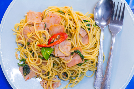 fusion food, spaghetti with fried crispy bacon ,sausage and basil leave, hot and spicy food, international cuisineの写真素材