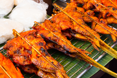 Grilling chickens plugged with bamboo.の写真素材