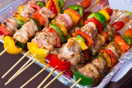 Skewered on wooden sticks tasty pork meat and vegetables mix, grilled meatの写真素材