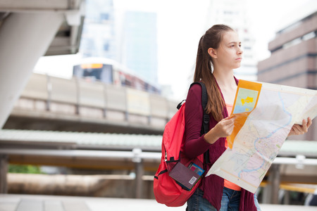Beauty foreigner traveler searching direction on location map while traveling in city, Feeling lost tourist searching the way to hotel on map foreign city during vacation in Thailandの写真素材