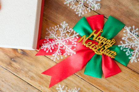 White gift box and red ribbon  on wood background with space.の写真素材