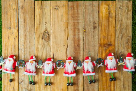 Christmas background with santa claus doll holding hands on wooden table background with a copy spaceの写真素材