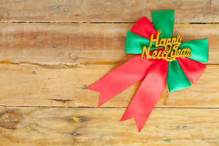 Red ribbon and Happy new year gift on wood background with space.の写真素材