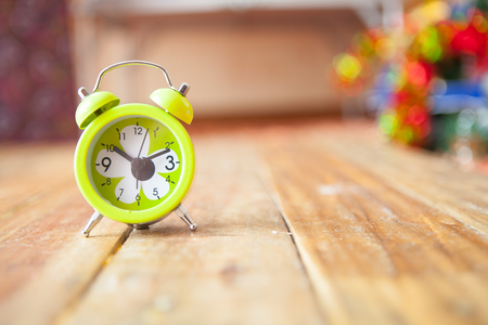 Green small alarm clock on wooden with selective focus and copy spaceの写真素材