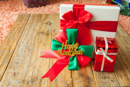 White gift box and red ribbon  on wood background with space.の写真素材