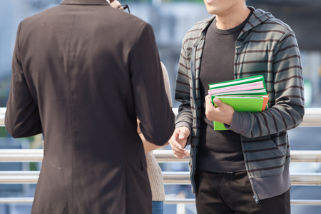 Businessman and college students discussing education  on outdoor backgroundの写真素材