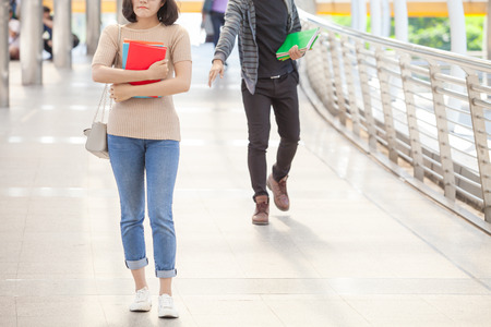 Man student running try to reach his friend during holdinh books in handsの写真素材