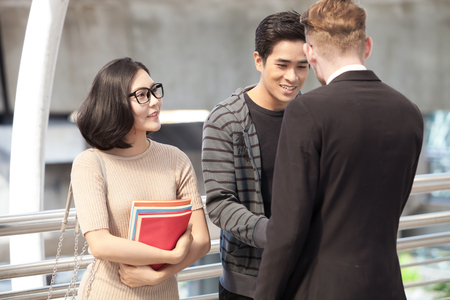 Businessman and college students discussing education  on outdoor backgroundの写真素材