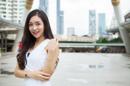 portrait of beautiful girl holding shopping bags and smiling while waliking the streetの写真素材