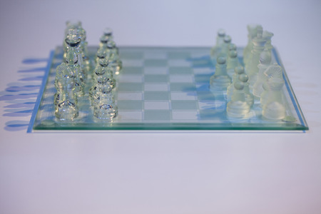 glass chess on the transparent chessboardの写真素材