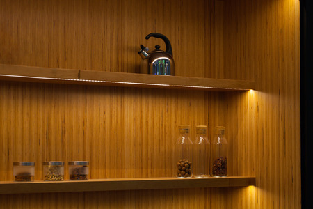 stainless steel electric kettle and herbal in bottles on shelfの写真素材