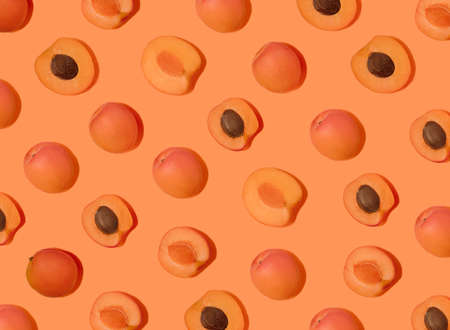 Colorful fruit pattern of fresh apricots on peach pastel background, top view, flat lay. summer...