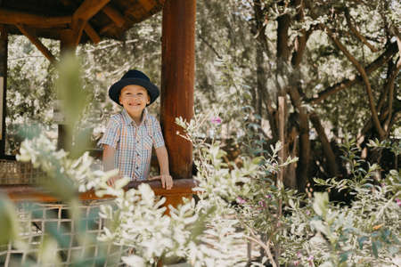Baby boy in a blue hat and shirt smiling. In the park, in the summer.の写真素材