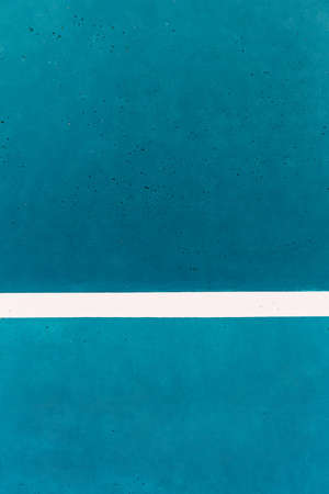 Blue wall for tennis training. Blue concrete texture with white stripe.