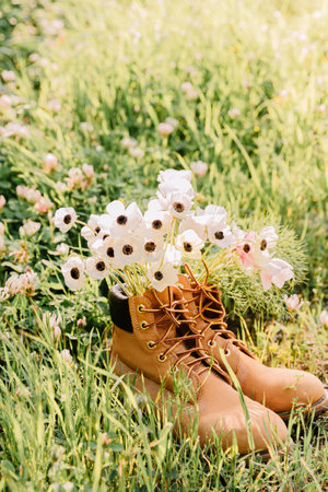 Shoes with a bouquet of white wildflowers anemone inside.