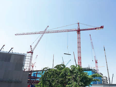 Tower Cranes working on construction site with safety scaffolding.の写真素材