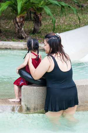BANGKOK , THAILAND - JUNE 12 : Unidentified woman teach to swim for her child on June 12 , 2008 in Siampark City , Bangkok , Thailand.Siampark City is a famous amusementpark in Thailand.のeditorial素材