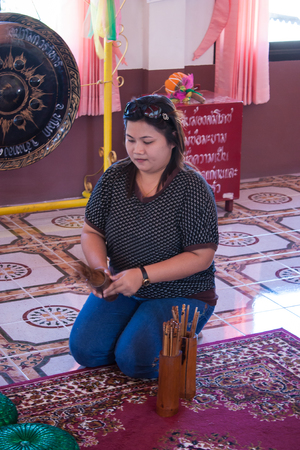 BANGKOK , THAILAND - JANUARY 1 : Unidentified woman shake a Chi-Chi Sticks for predicton on January 1 , 2009 in Buddhism temple , Bangkok , Thailand.のeditorial素材