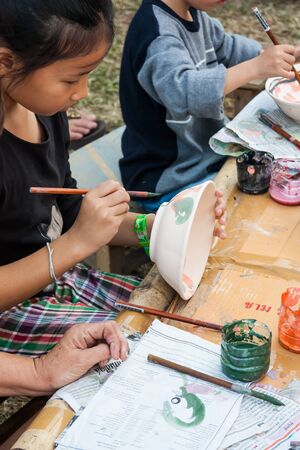 BANGKOK -  JANUARY 17: An unidentified girl paint a bowl  in Thailand Tourism Festival 2015 at Lumphini Park on January 17, 2015 in Bangkok, Thailand.のeditorial素材