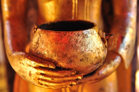 Buddha statue with a begging bowlの写真素材