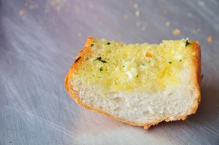 A piece of garlic bread on the shiny surface