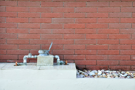 House water-meter in front of red brick wallの写真素材